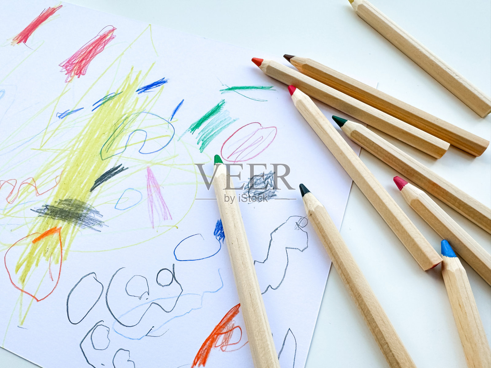 彩色铅笔在儿童绘画的背景上。前视图。照片摄影图片