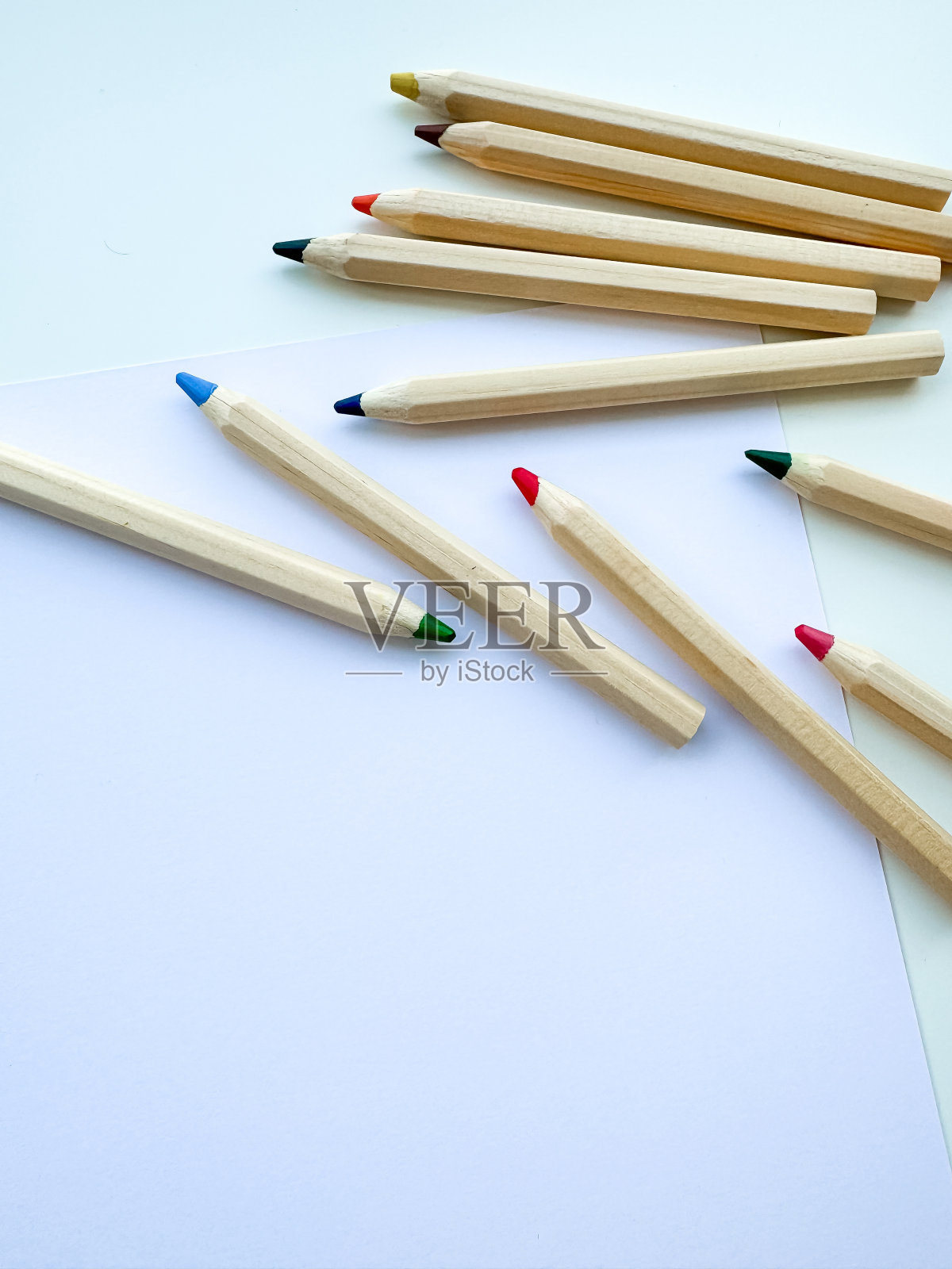 彩色铅笔放在桌子上，纸上，白色背景上。前视图。照片摄影图片