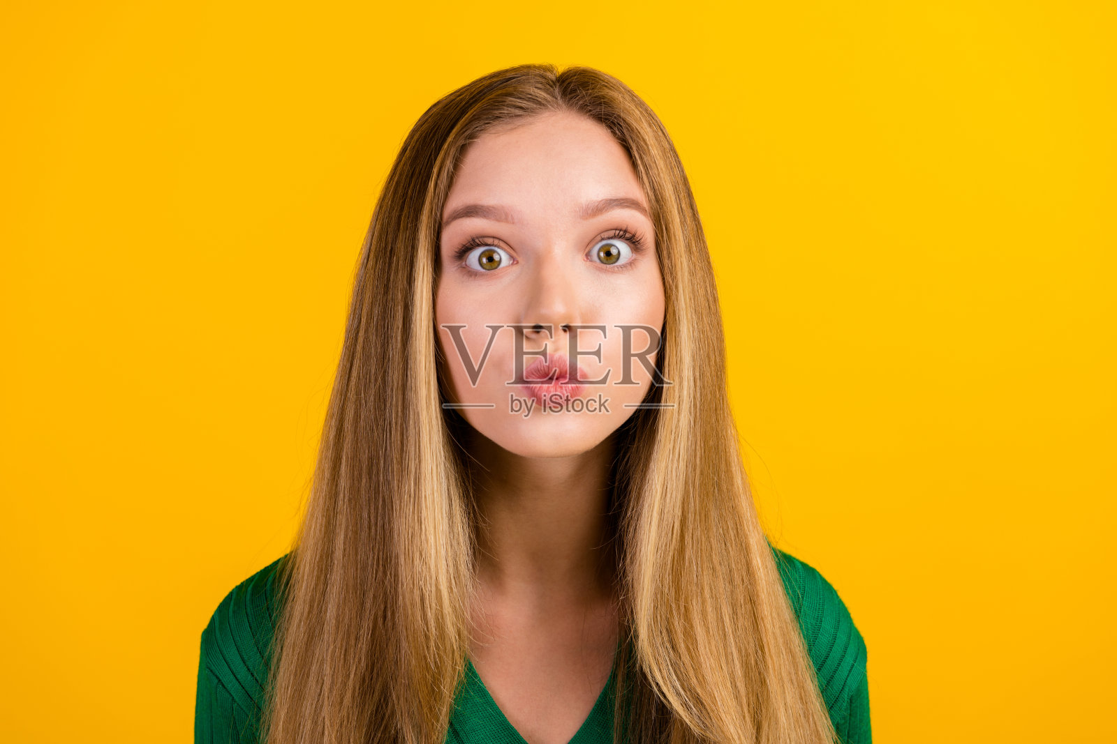 可爱的甜美轻浮的女孩的肖像噘起嘴唇空吻表达感情孤立的黄色背景照片摄影图片