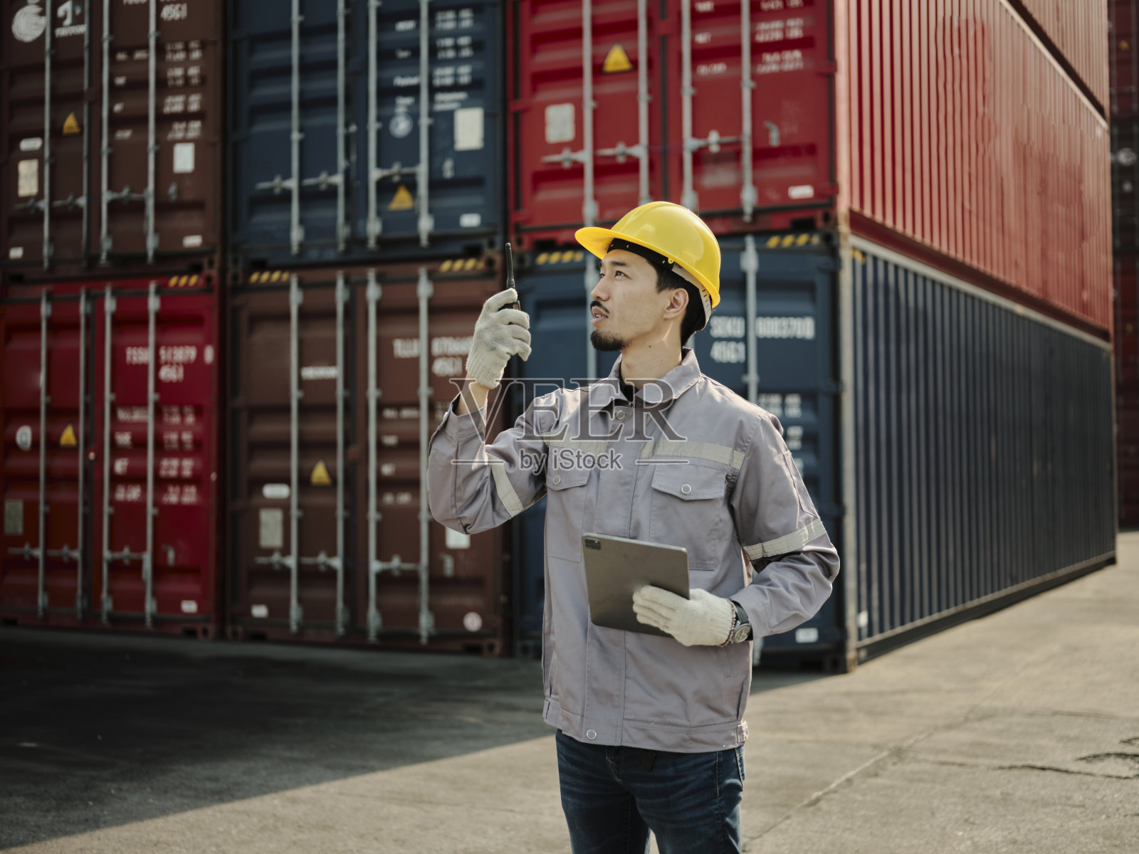 亚洲工人戴安全帽，使用对讲机照片摄影图片