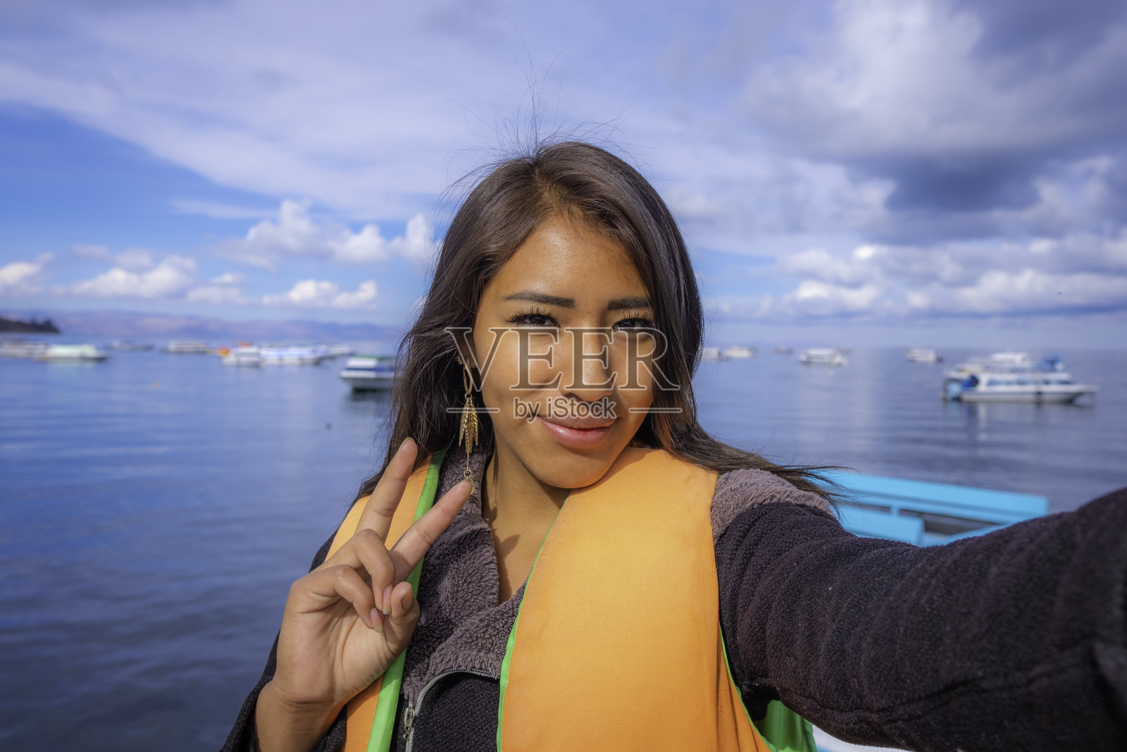 快乐的拉丁女人在度假时在玻利维亚的的的喀喀湖自拍照片摄影图片