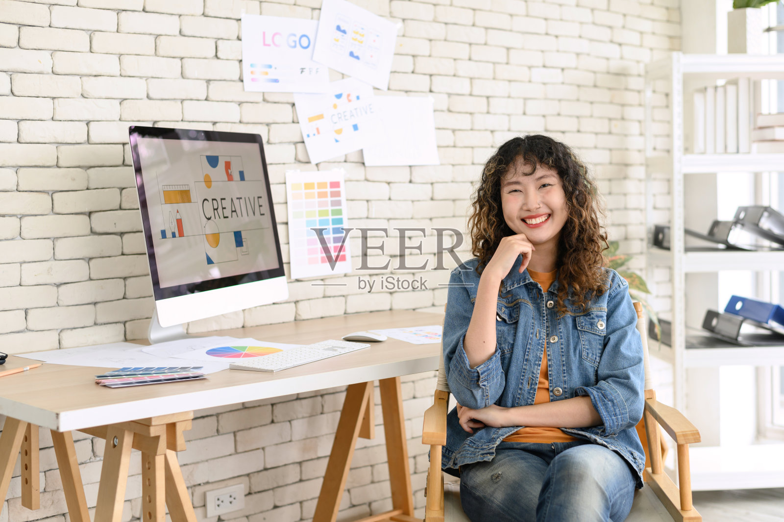 办公室里快乐的女性平面设计师的肖像。有创意的人们在集体头脑风暴中用数码电脑摆姿势时对着镜头微笑。照片摄影图片