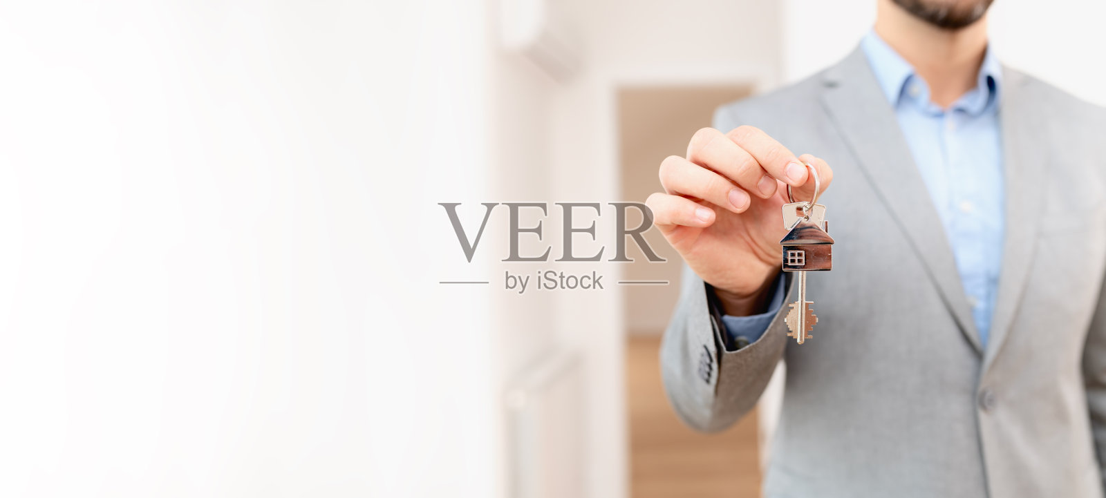 房地产经纪人持有房产的钥匙。买房子。房地产和抵押的概念。照片摄影图片