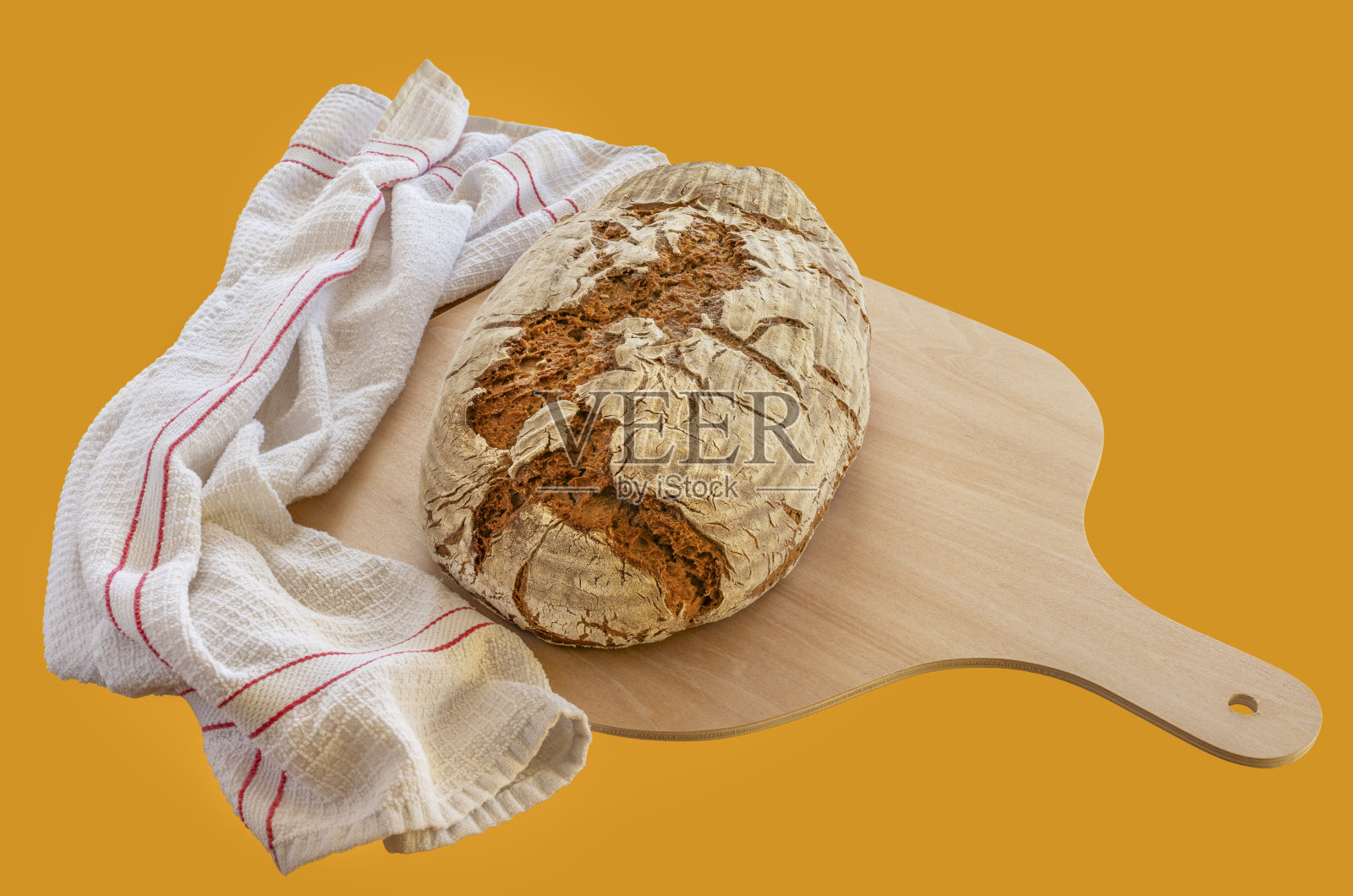 刚烤好的面包放在木铲和茶巾上照片摄影图片
