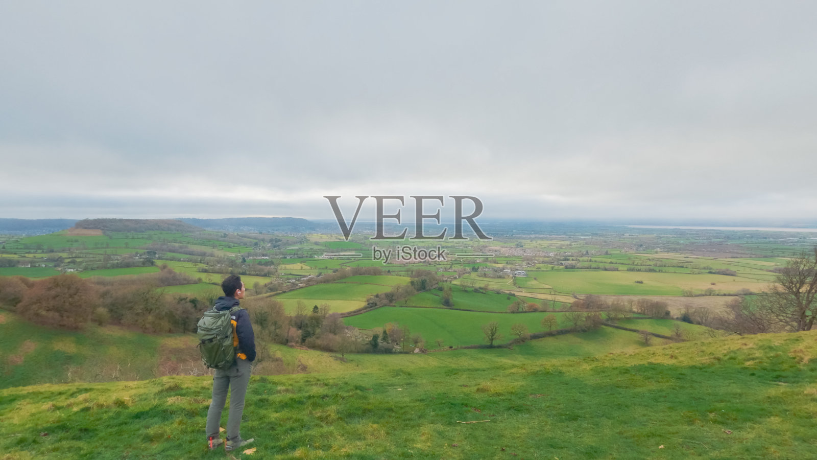 在英国格洛斯特郡斯特劳德科尔利峰高地上的背包客徒步旅行者照片摄影图片