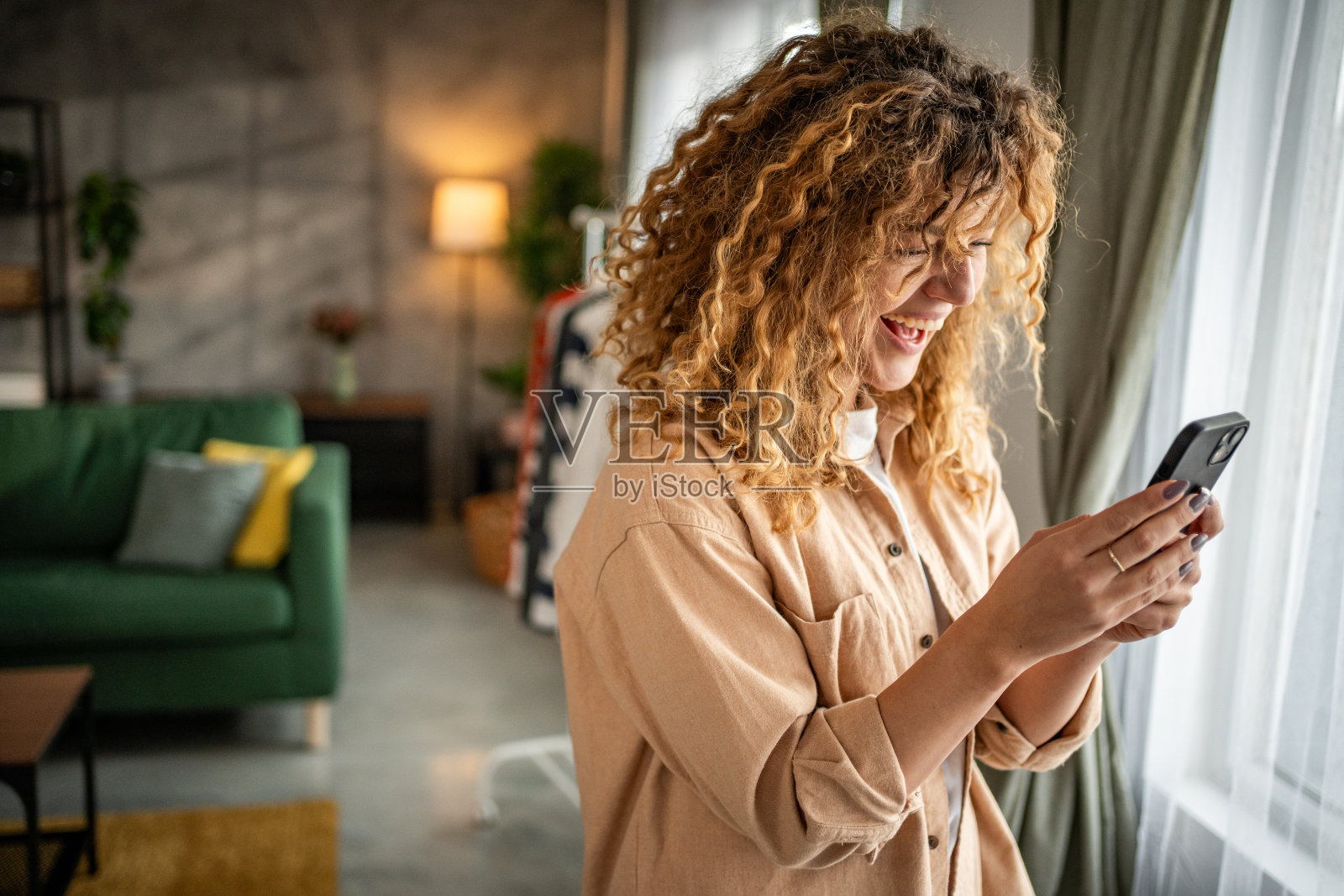 快乐的年轻美女用智能手机打字照片摄影图片