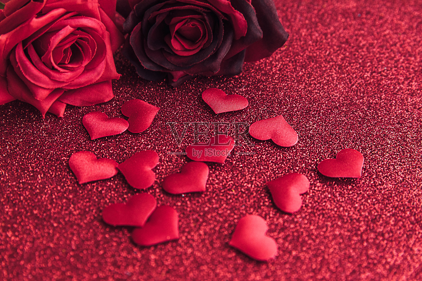 情人节的概念。红色的玫瑰和许多红色的心在红色闪闪发光的背景。情人节的明信片横幅。恋爱约会相思婚礼浪漫象征。情人节礼物。照片摄影图片