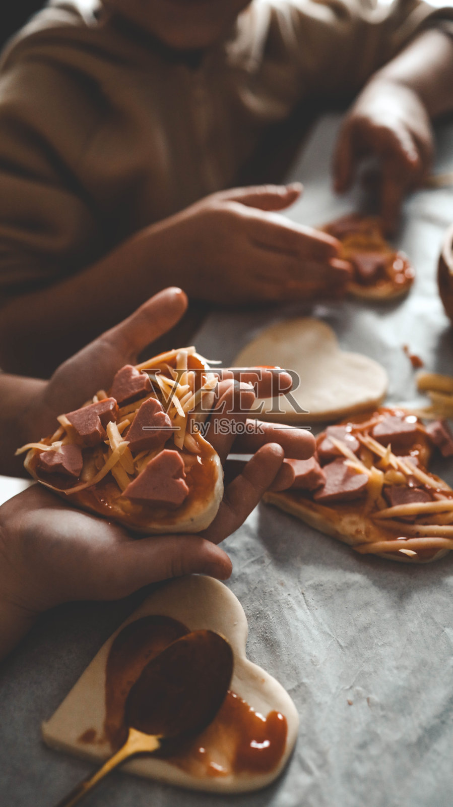 母亲节，妈妈和孩子在厨房里做披萨，幸福家庭的概念照片摄影图片