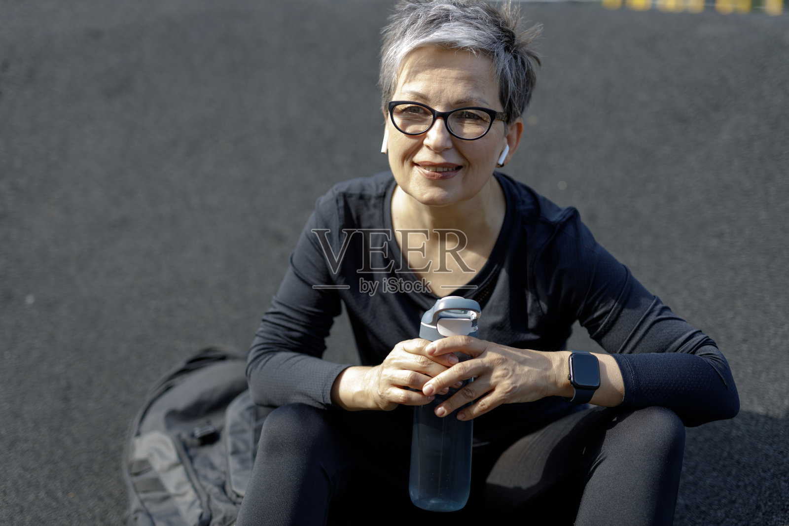 一个成熟的女人在城市环境中，在早晨的马拉松例行公事中散发出活力。照片摄影图片