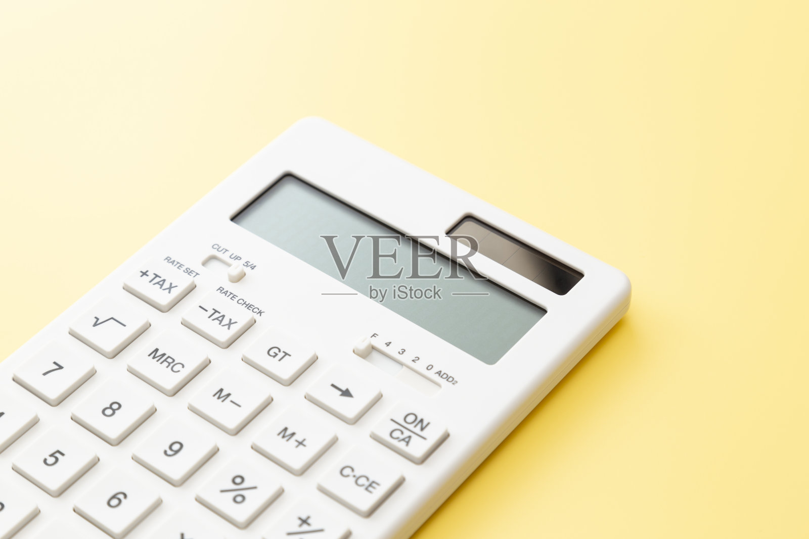 黄色背景上的计算器。照片摄影图片