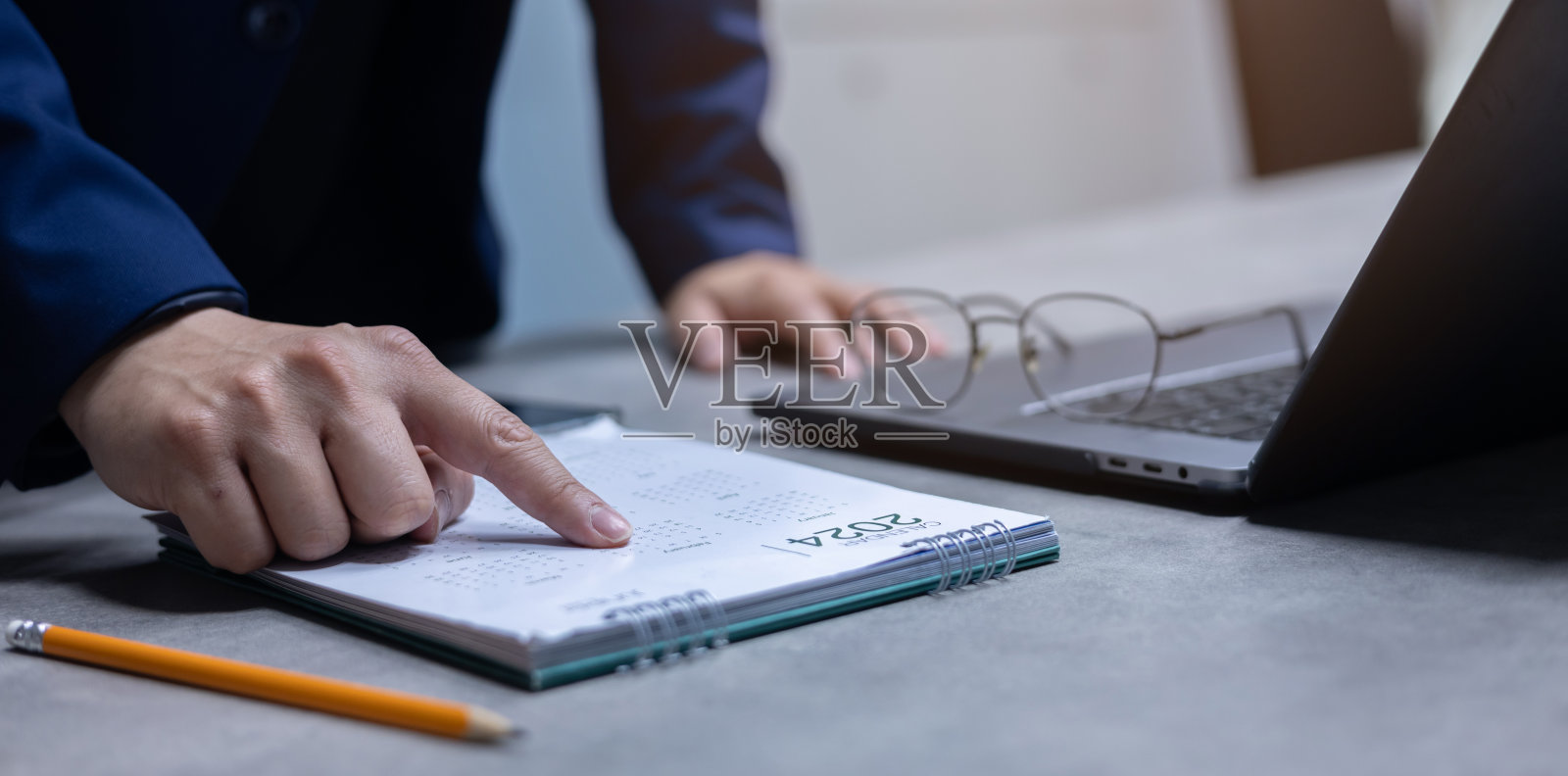 根据2024年日历上经理的手点日期制作清单或准备在办公室私人房间的预约会议日，以实现工作与生活的平衡照片摄影图片