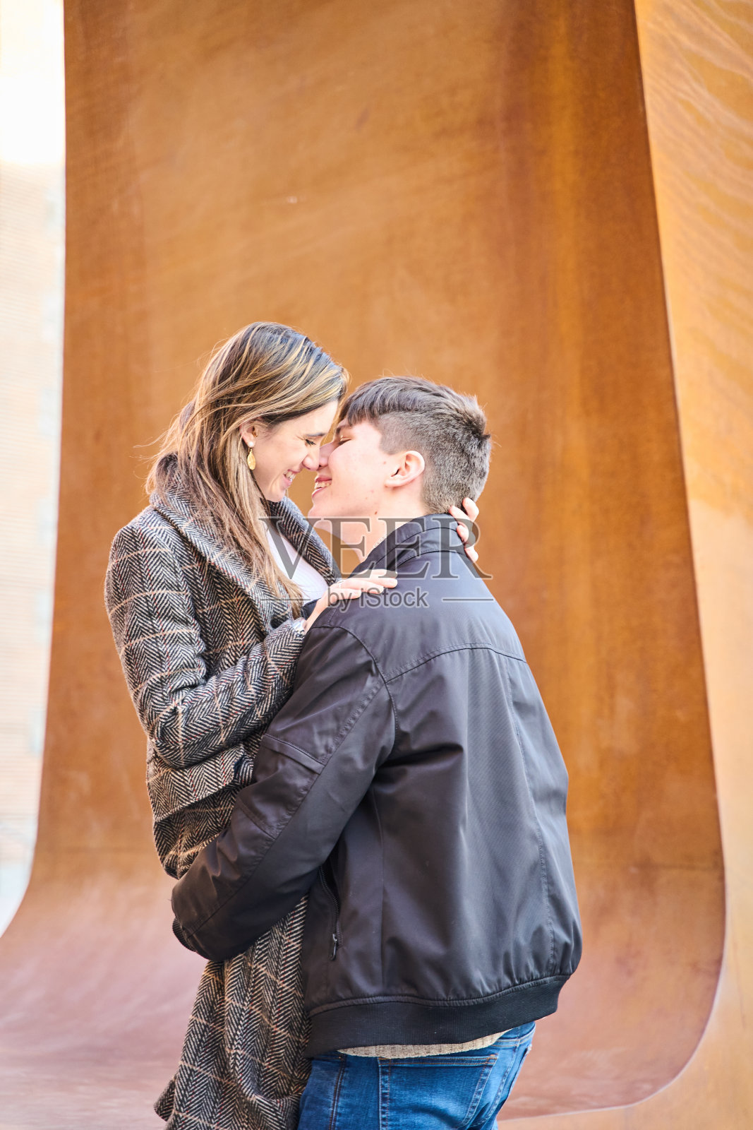 年轻情侣在街上亲吻拥抱。情侣们满怀激情地庆祝情人节照片摄影图片