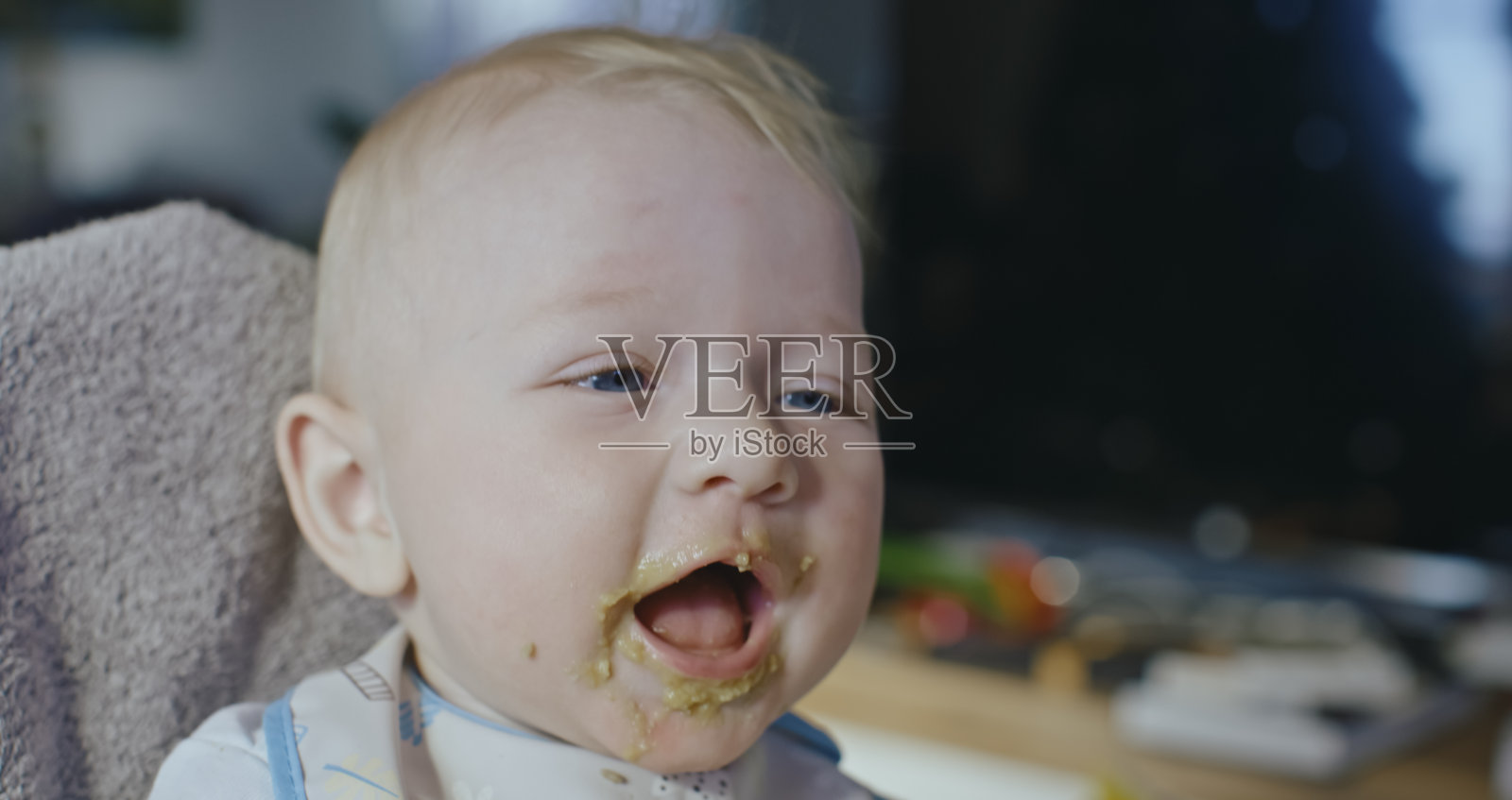 可爱的男孩学步与涂抹食物的嘴照片摄影图片