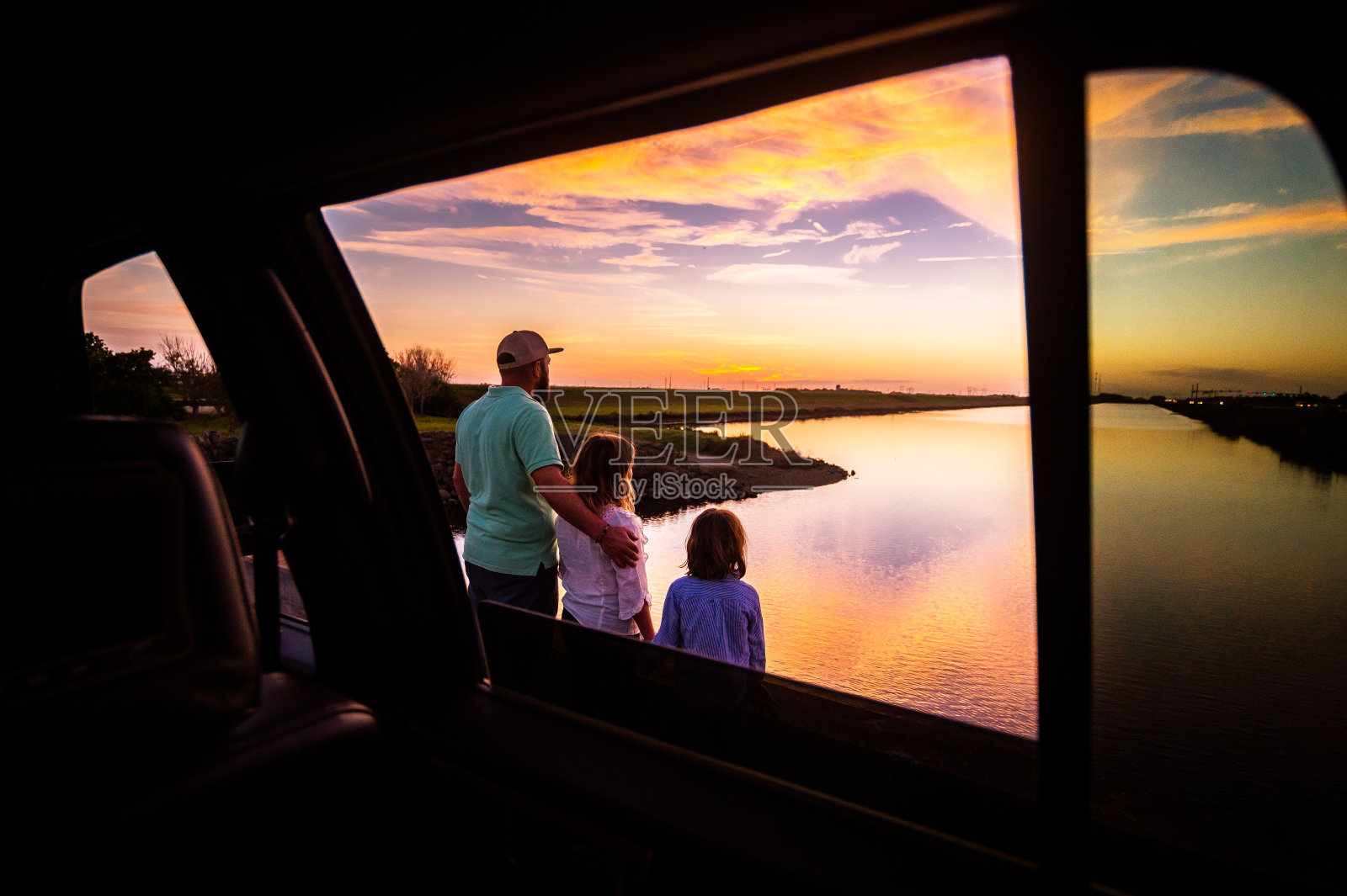 男人和孩子，父亲和女儿，在公路旅行与汽车一起看美丽的日落照片摄影图片