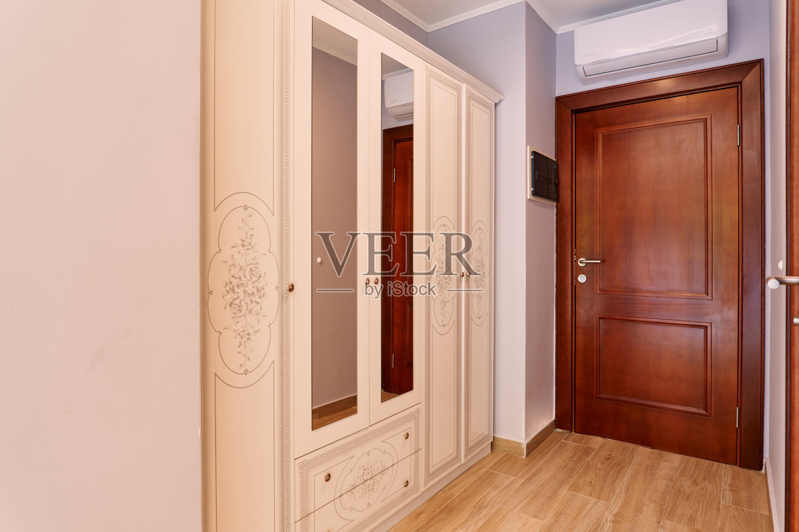 酒店房间入口处的米色衣橱配有镜子照片摄影图片