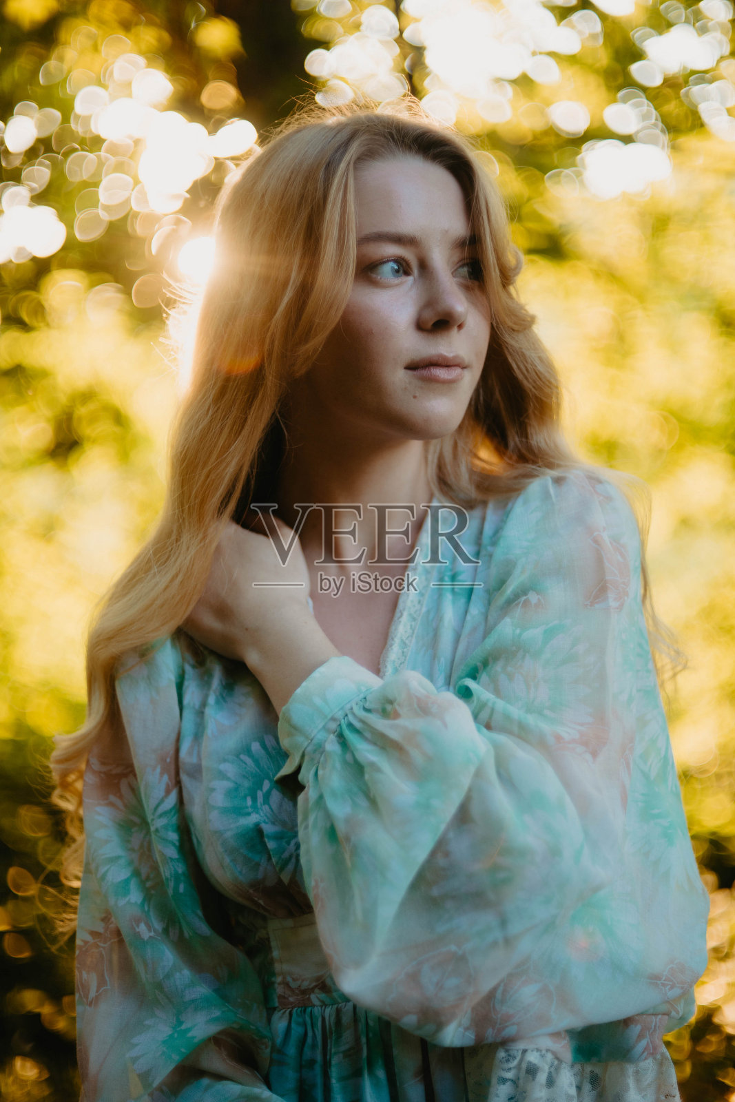 可爱的年轻金发女郎在夏天穿着连衣裙在森林里晒太阳，夏日的概念和梦想的开始放松照片摄影图片