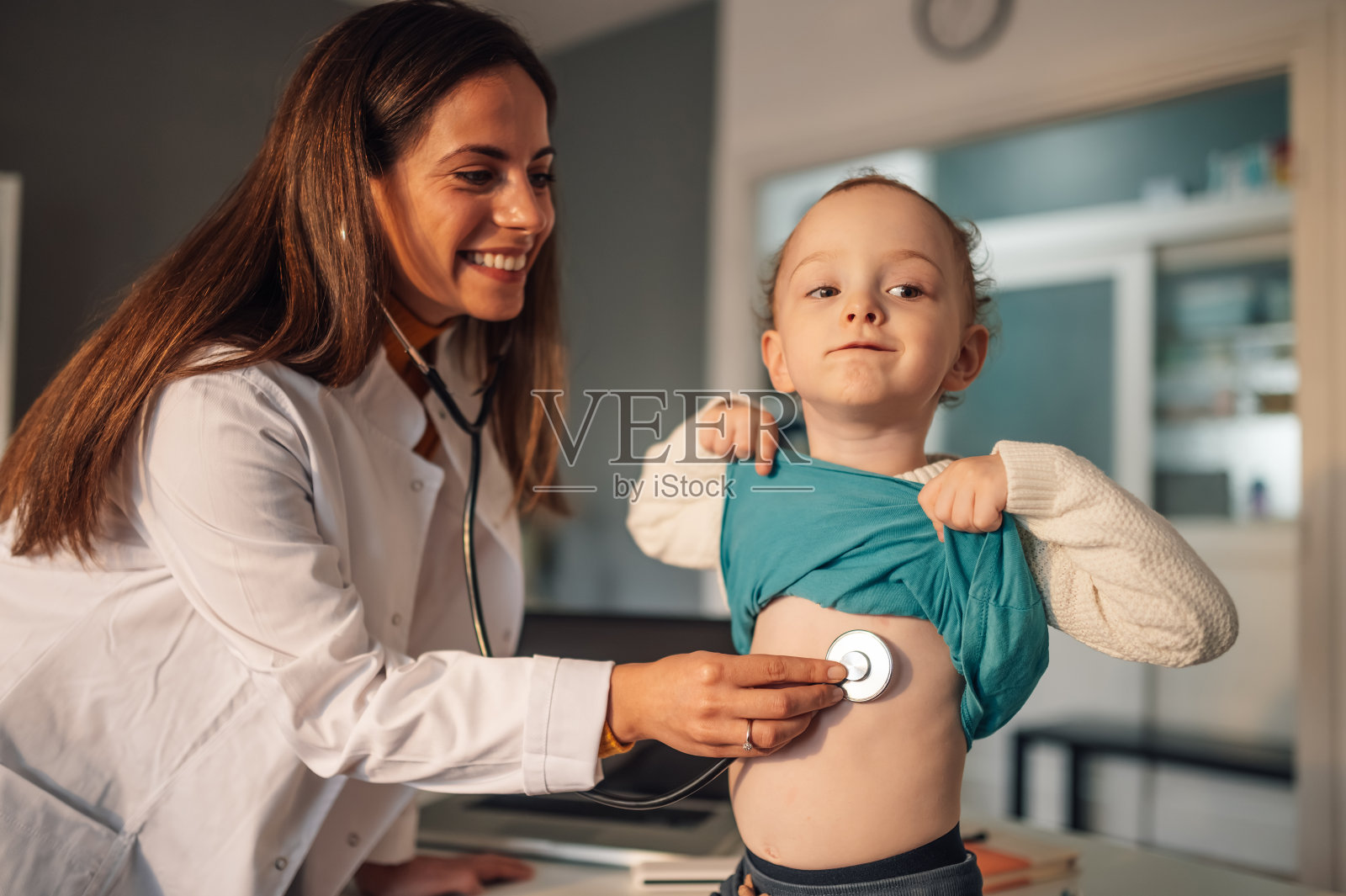 女儿科医生用听诊器检查一个小男孩的呼吸照片摄影图片