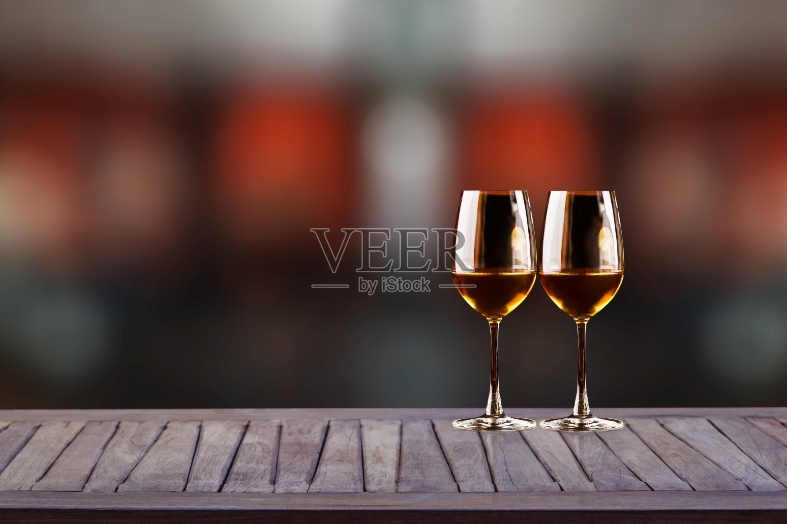 木制的桌子上放着酒杯，在黑暗的背景上有模糊的散景。餐厅提供,restaurant-restaurant。照片摄影图片