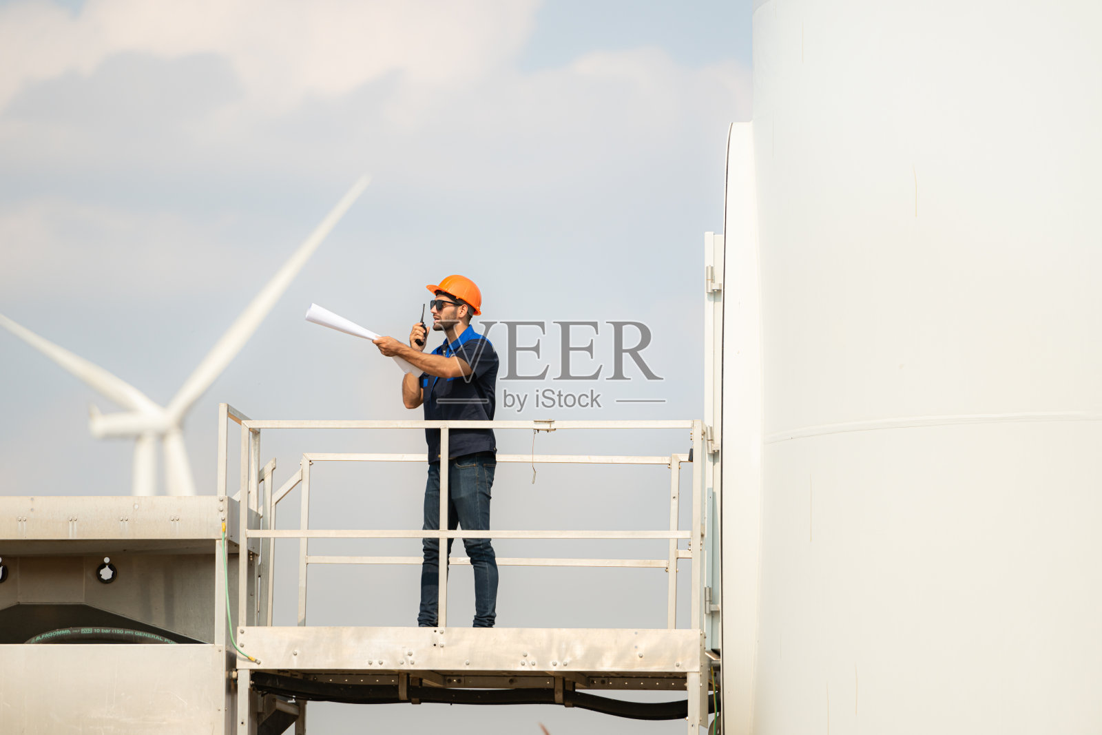 技术人员在风力发电场检查风力涡轮机以进行维护。照片摄影图片