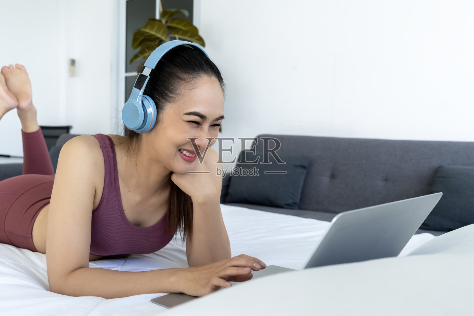 女人在卧室的床上使用笔记本电脑照片摄影图片