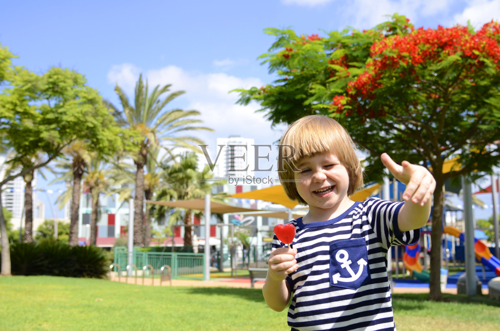 幼儿园里吃棒棒糖的学龄前男孩照片摄影图片