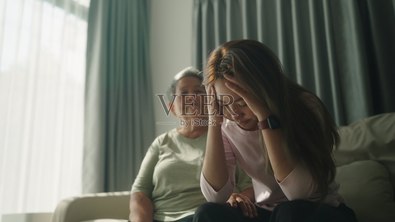 老年妇女安慰青少年。照片摄影图片