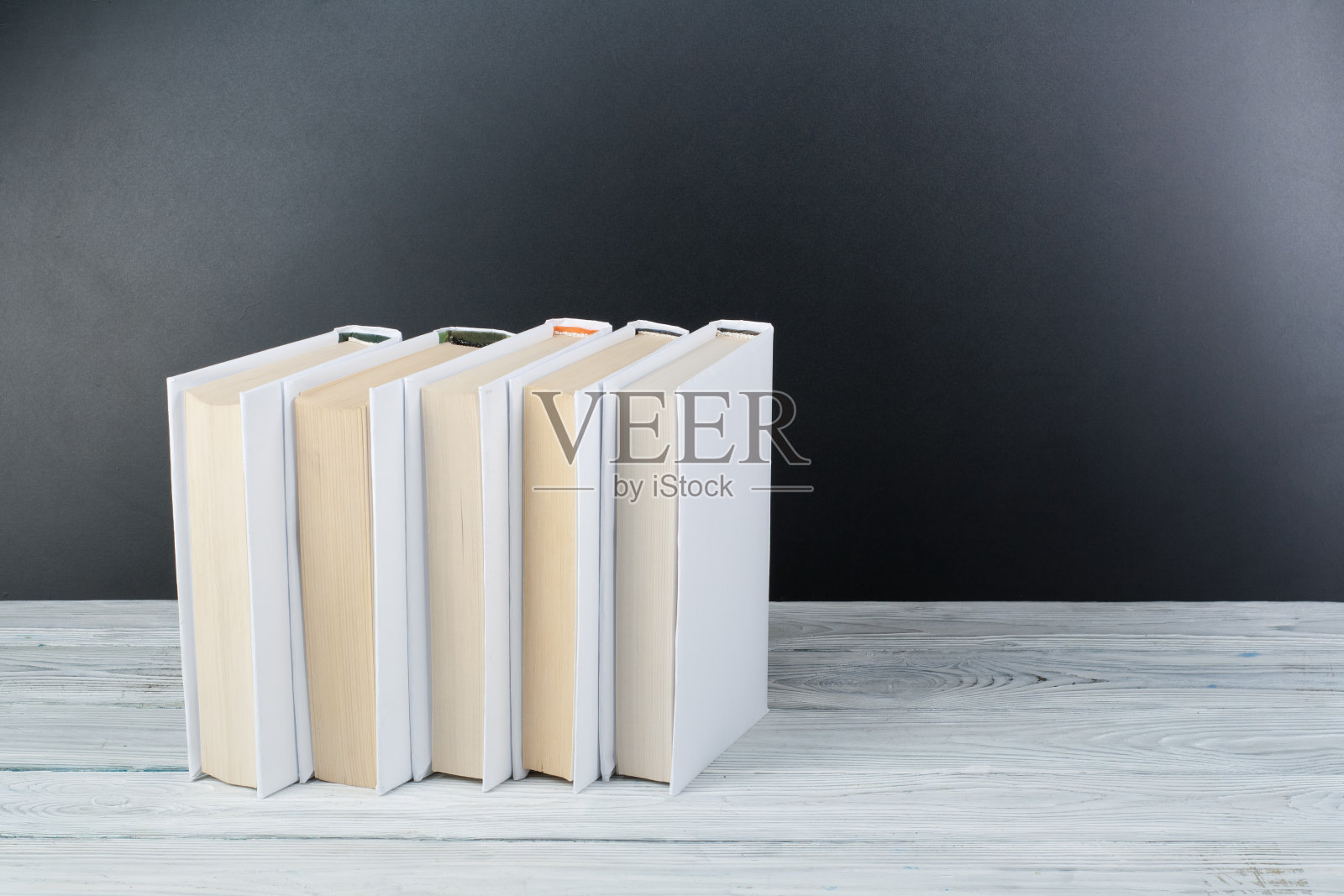 打开书本放在木桌上，黑板背底。回到学校。教育经营理念。照片摄影图片