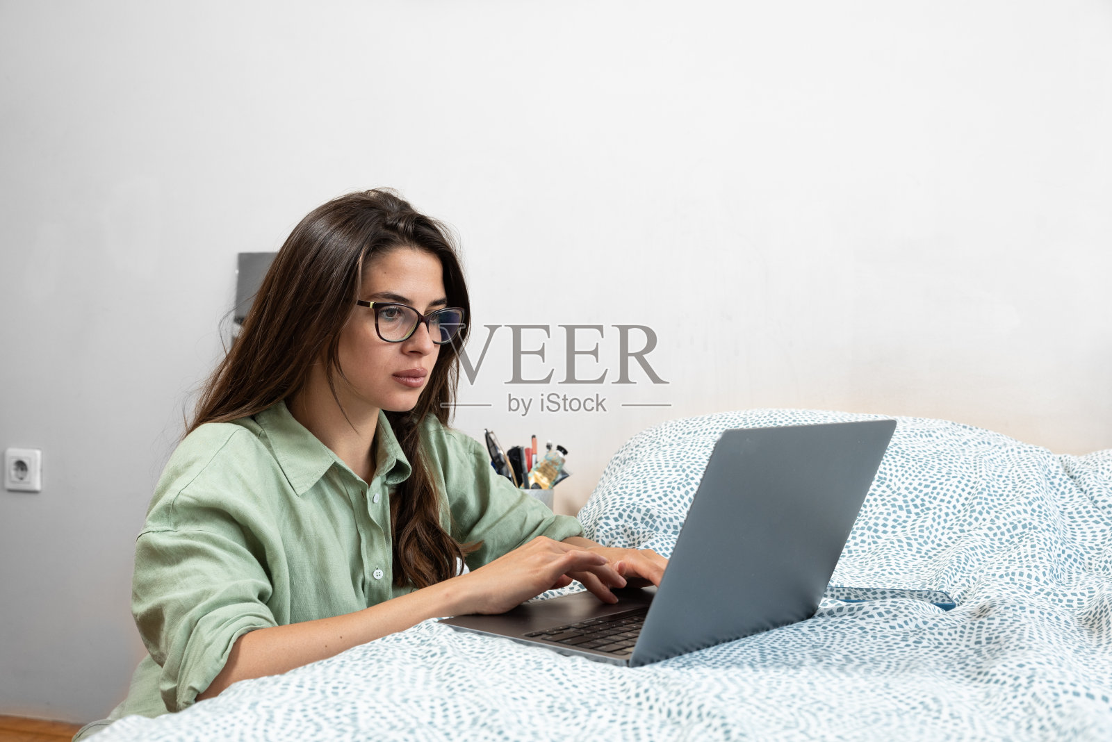 简单的生活。年轻的自由职业女性作为产品策略专家在家用笔记本电脑工作。女性外籍人士远程工作在互联网上的电脑在线为外国公司作为网页开发人员。照片摄影图片