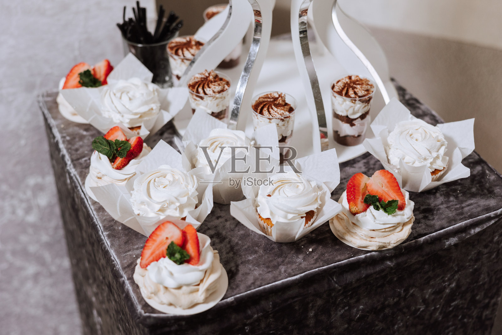 为婚宴准备的杏仁饼干和各种甜蛋糕。一场美味的招待会，一场奢华的仪式。桌上摆满了糖果和甜点。美味的彩色法国甜点在盘子或桌子上。照片摄影图片