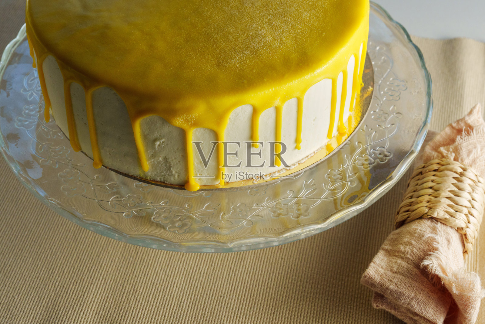 蛋糕优雅地放在玻璃架子上，上面装饰着闪闪发光的柠檬釉照片摄影图片