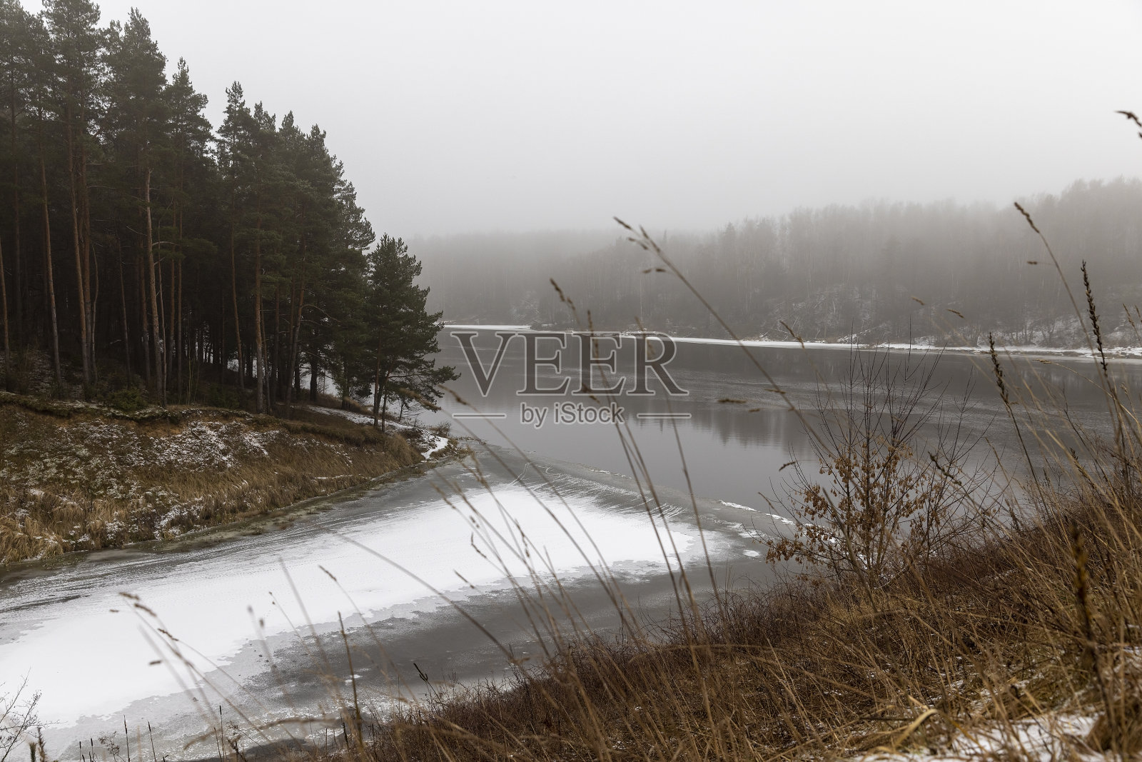 在冬天多雾的天气里，河岸和水照片摄影图片