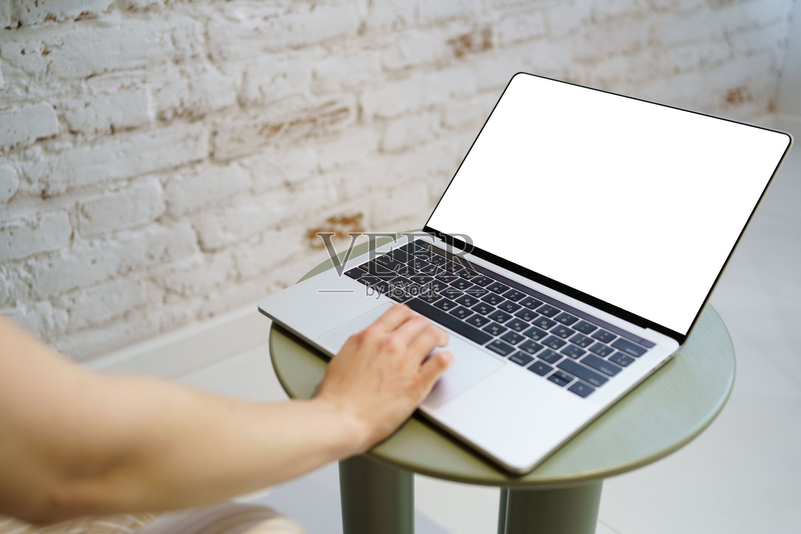 女人用手在笔记本电脑键盘上打字，房间里有一个模拟的空白屏幕。图片为您的设计和广告。在线课程，远程办公，购物理念照片摄影图片