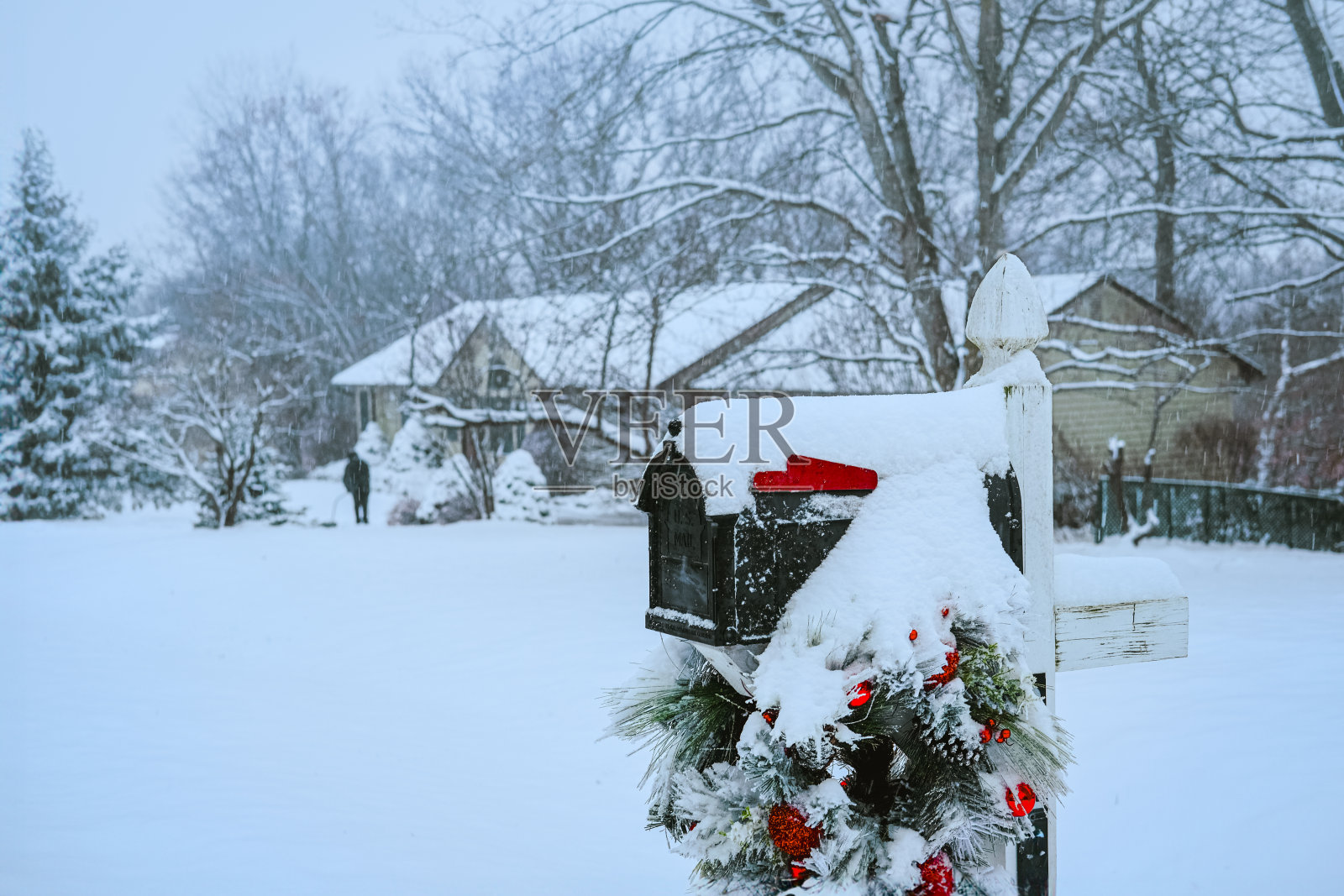 美国中西部地区积雪覆盖的地面上装饰着圣诞花环的邮箱照片摄影图片