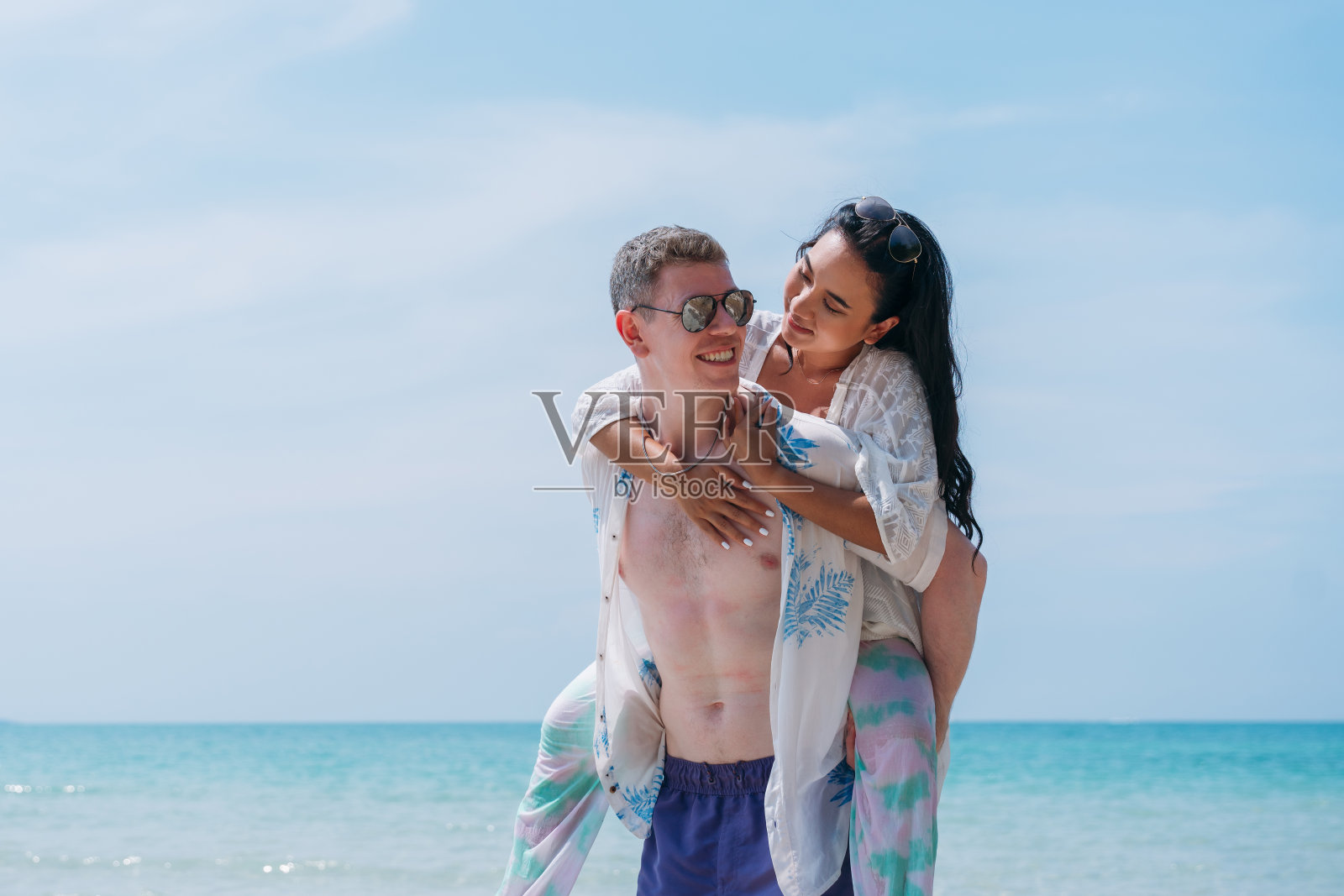 一对幸福相爱的年轻夫妇在热带海滩上享受时光。在海边享受快乐和浪漫的情侣照片摄影图片