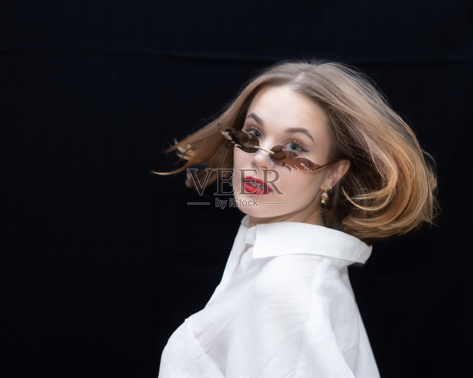 女孩突然把头扭到一边，她的头发飘了起来，女孩严肃地看着镜头照片摄影图片