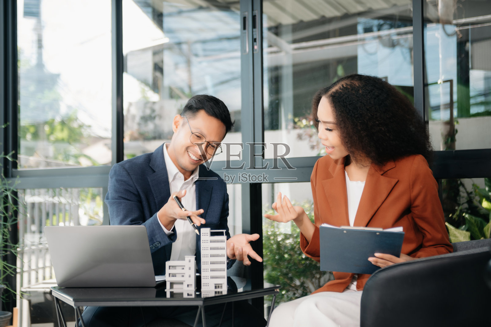 房地产经纪人向客户提出并咨询决策签订保险合同、房屋模型、有关按揭贷款报价照片摄影图片