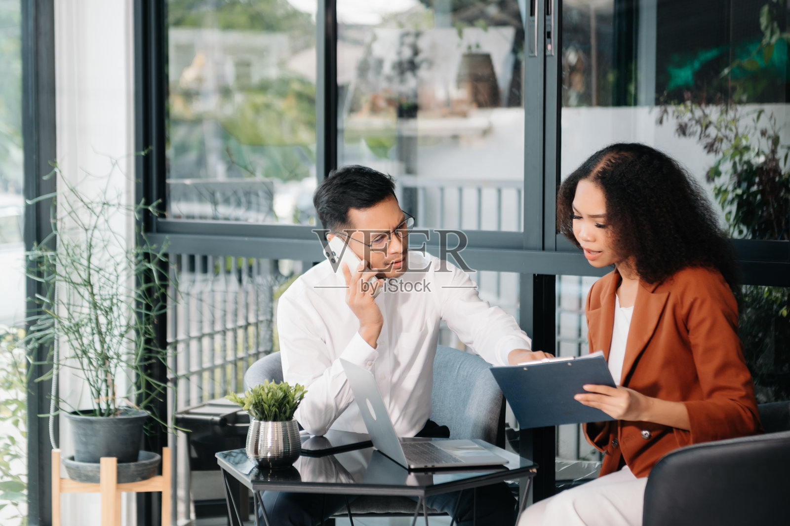 两个亚洲商人男女用平板电脑讨论投资项目工作和计划策略照片摄影图片