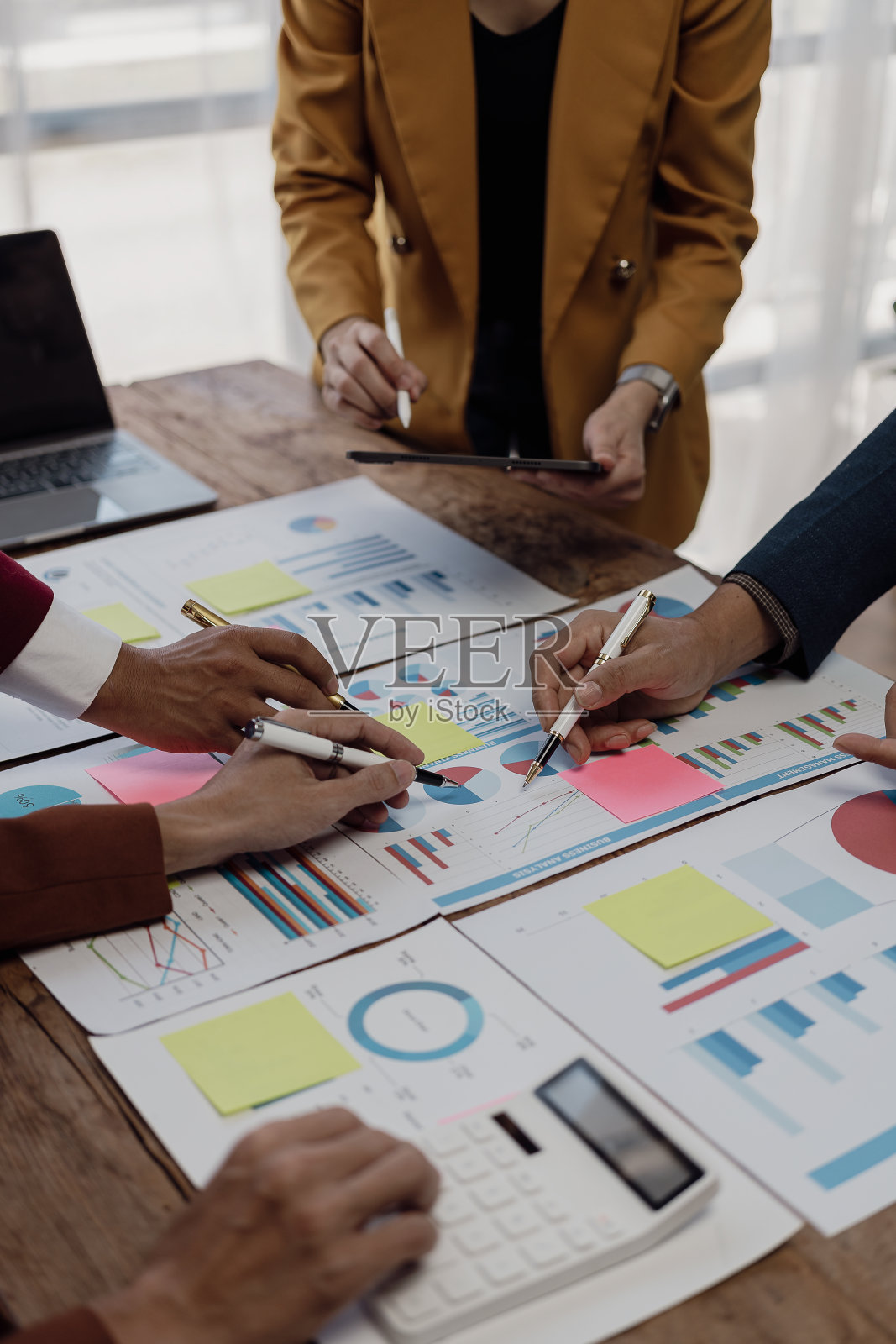 企业财务分析师在公司解决方案会议上讨论投资项目规划时的垂直镜头，显示团队合作的成功。特写镜头。照片摄影图片