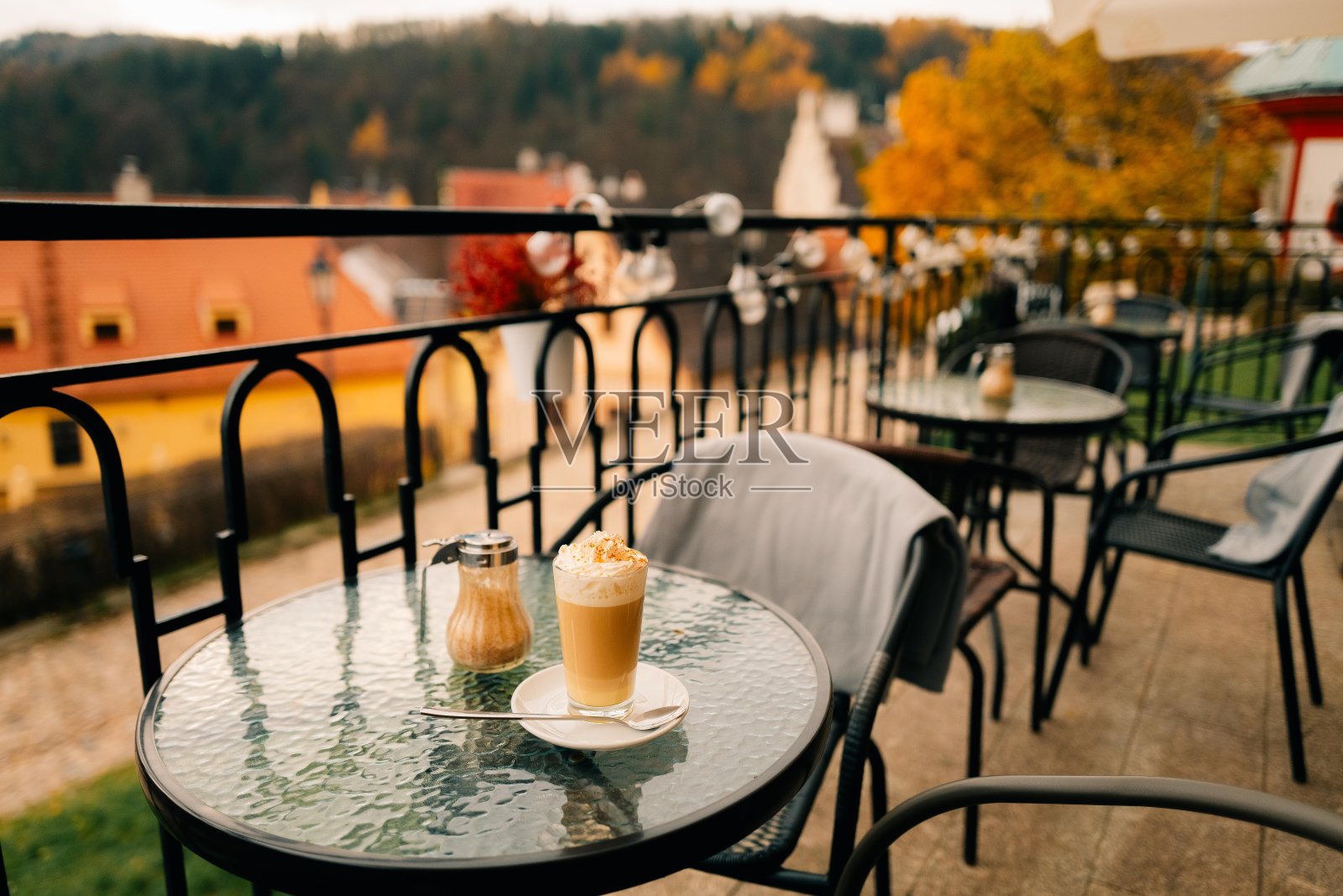 秋天，在一个古老的欧洲小镇的户外咖啡馆里喝拿铁咖啡照片摄影图片