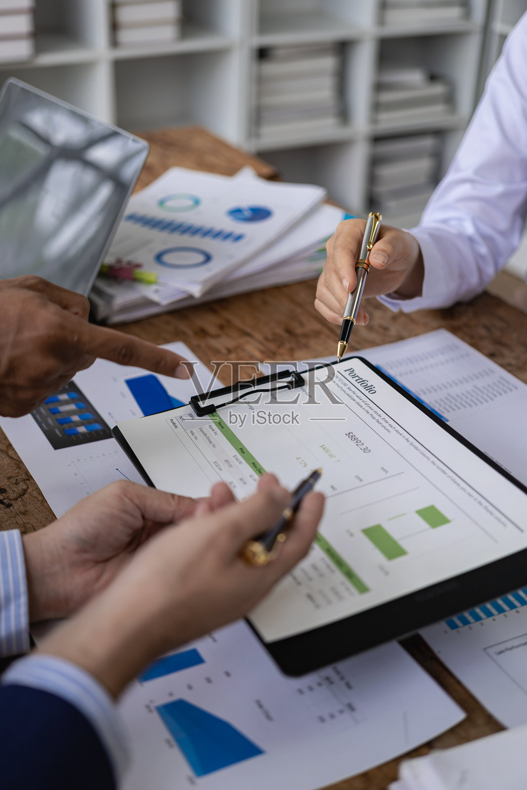 企业财务分析师在公司解决方案会议上讨论投资项目规划时的垂直镜头，显示团队合作的成功。特写镜头。照片摄影图片