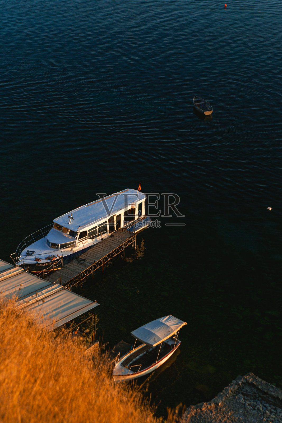 一艘白色的船停在码头上，周围有木筏照片摄影图片