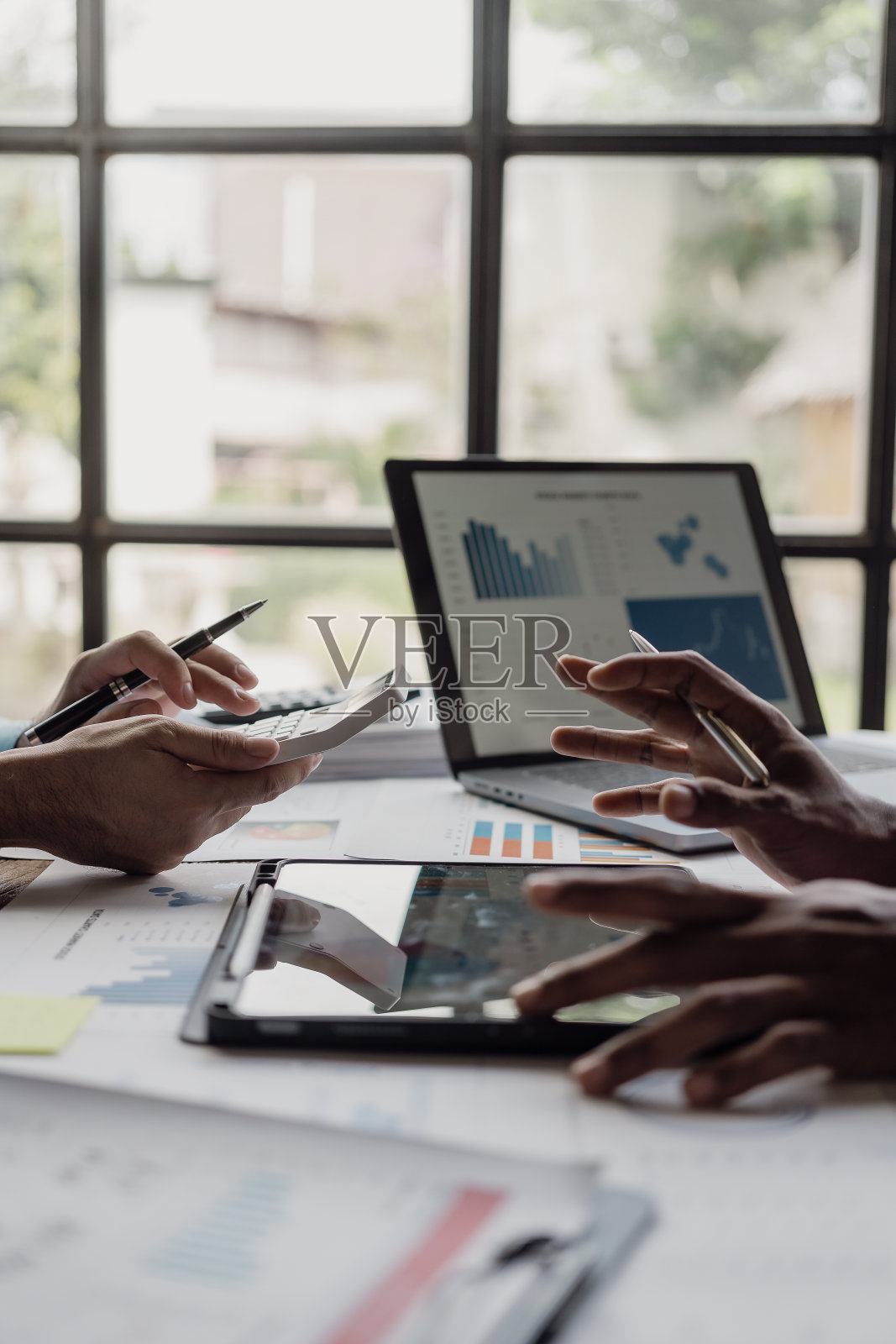 企业财务分析师在公司解决方案会议上讨论投资项目规划时的垂直镜头，显示团队合作的成功。特写镜头。照片摄影图片