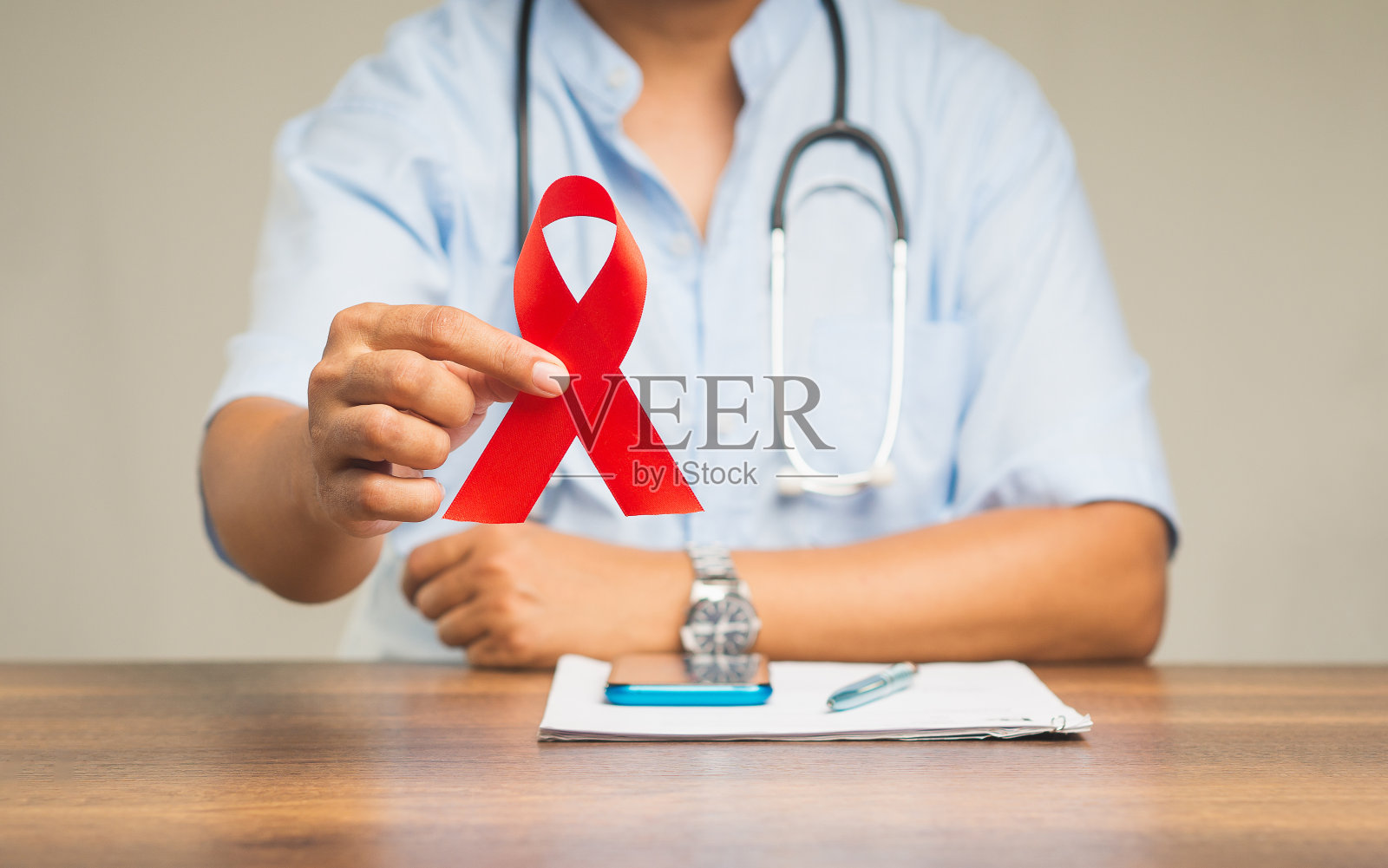 世界艾滋病日。手握红丝带标志的特写。照片摄影图片