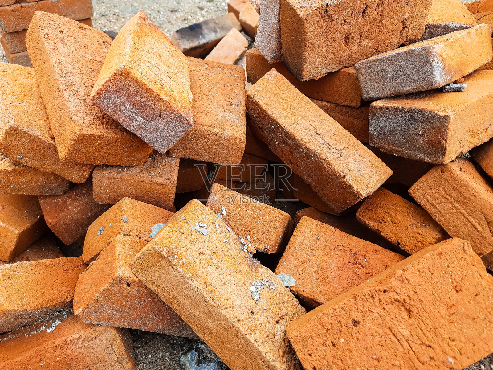 一堆不规则的橙色砖，用来砌墙照片摄影图片