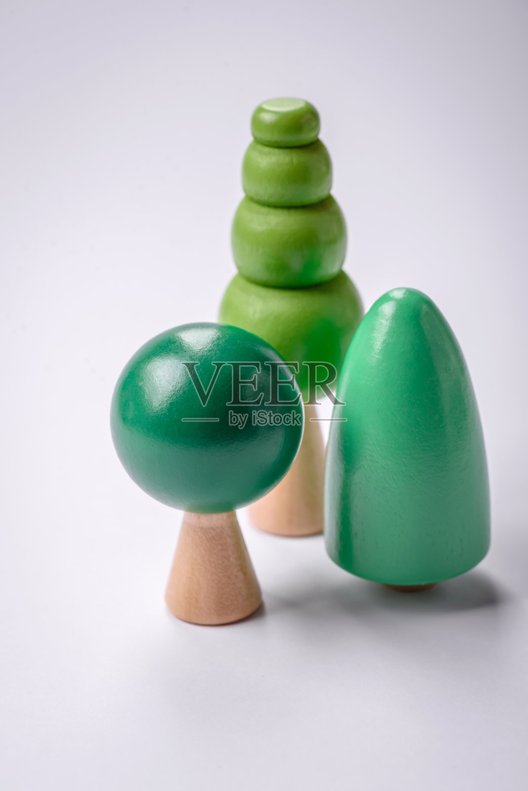 在白色背景上有绿色树冠和树干的木模型照片摄影图片