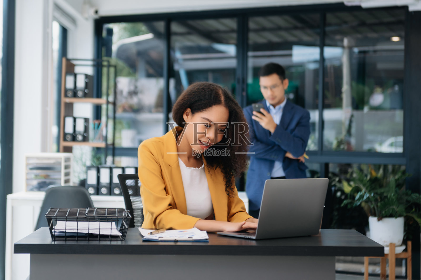 在办公室用记事本、平板电脑和笔记本电脑工作的女商人照片摄影图片