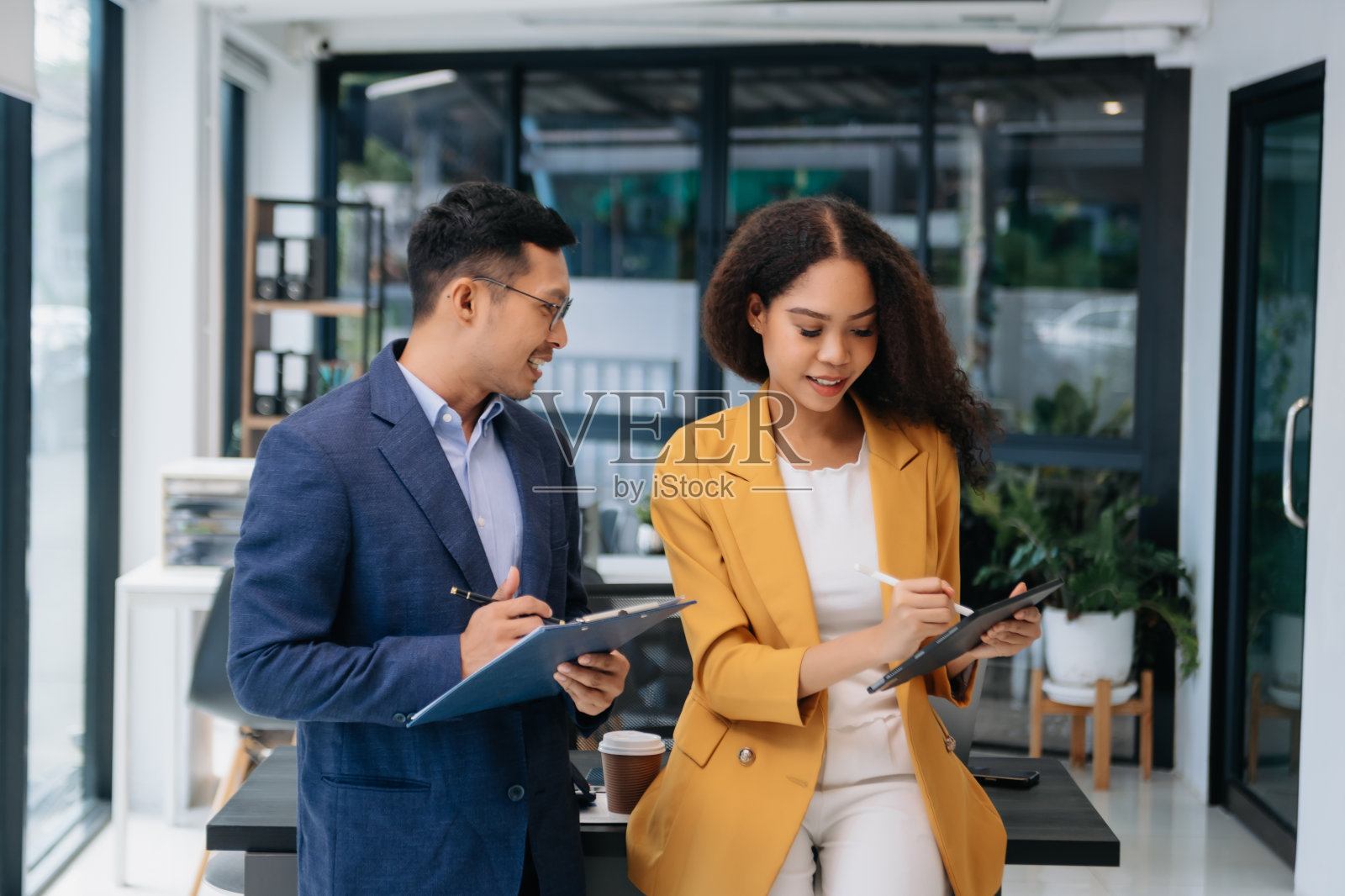 女商人工作并讨论她们的商业计划。一名人类员工向她的同事解释并展示了结果报告照片摄影图片