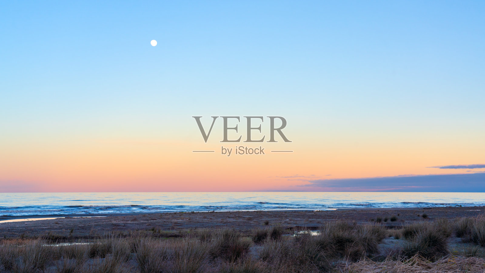 海边的黄昏，天上的月亮照片摄影图片