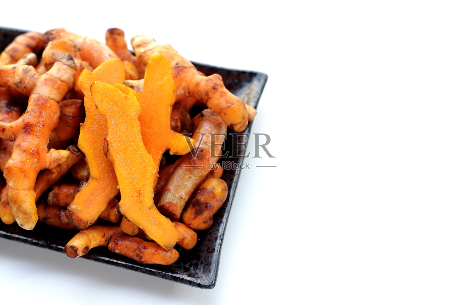 白色背景上的姜黄根。照片摄影图片