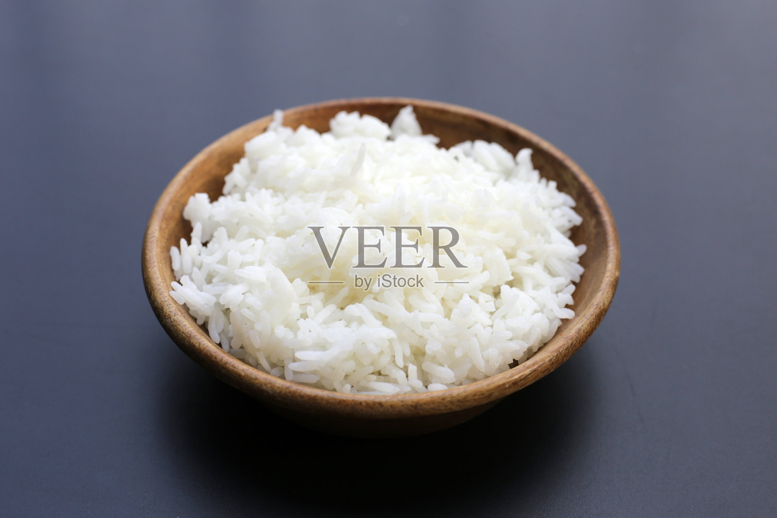 深色背景上煮熟的米饭。照片摄影图片
